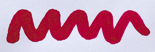 Wavy pink line on a white background. Diamine Amaranth fountain pen ink colour swatch.